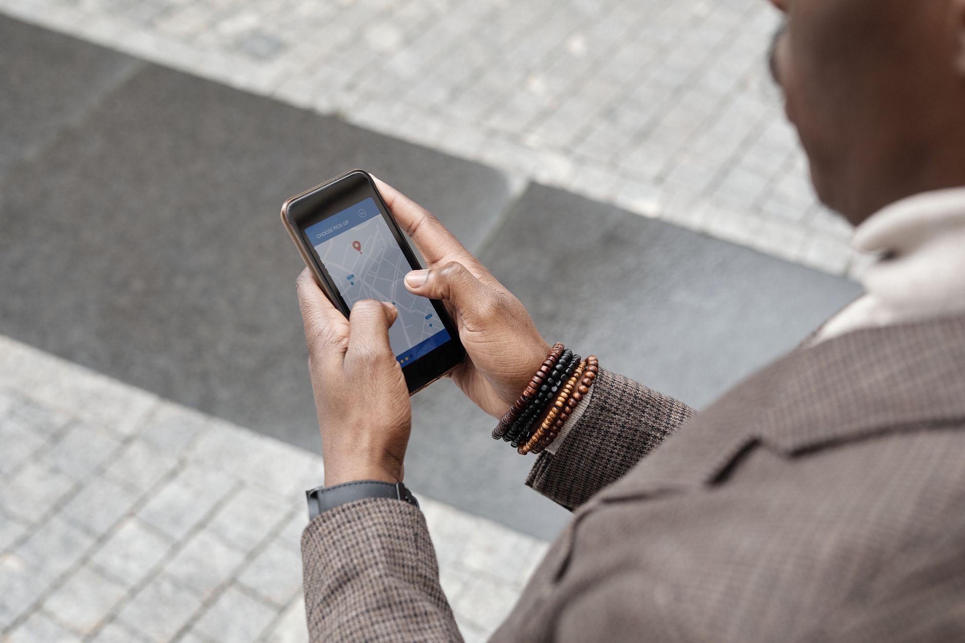 Profissional usando um smartphone com app de navegação em uma rua urbana